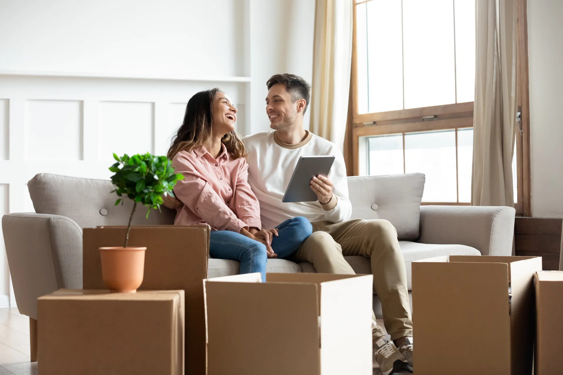 Paar mit Umzugskartons im neuen Wohnzimmer
